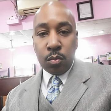 handsome black man in grey suit with the lips of a YN